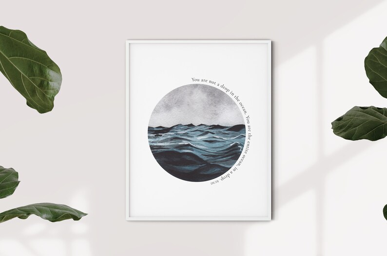May include: A framed print with a watercolor illustration of a stormy ocean in a circle. The text "You are not a drop in the ocean. You are the entire ocean in a drop" is written around the circle.
