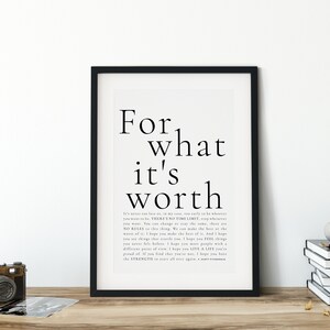 May include: Black and white typography print with the text "For what it's worth" and a quote about making the best of life. The print is framed in a black frame and is displayed on a wooden surface.