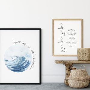 May include: Two framed prints with inspirational quotes. The first print features a blue watercolor wave with the text "Love is the sunshine warm in the sea, sweet after the storm". The second print features the text "Wonder -  Finding beauty in imperfection, the discovery of beauty and harmony in the refined and simple things in life, the acceptance of the cycle of life and death."