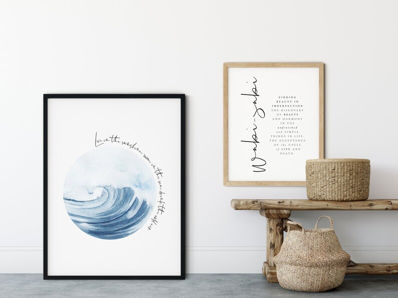 May include: Two framed prints with inspirational quotes. The first print features a blue watercolor wave with the text "Love is the sunshine warm in the sea, sweet after the storm". The second print features the text "Wonder -  Finding beauty in imperfection, the discovery of beauty and harmony in the refined and simple things in life, the acceptance of the cycle of life and death."