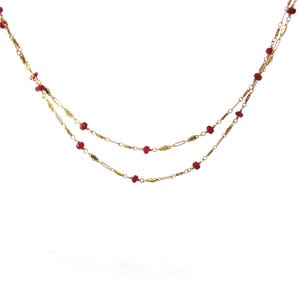 Puede incluir: Un delicado collar dorado con dos hilos. Cada hilo está adornado con pequeñas cuentas rojas vibrantes espaciadas a lo largo de la cadena. El collar está diseñado con un estilo simple y elegante, perfecto para el uso diario.