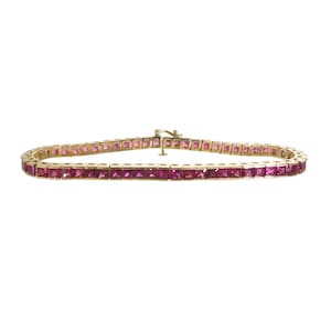 Könnte beinhalten: Ein goldenes Armband mit einer Reihe quadratischer rosafarbener Edelsteine.
