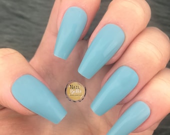May include: A set of long, light blue press-on nails. The nails are all the same shape and size, and they have a smooth, glossy finish.
