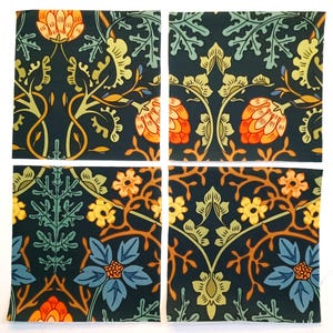 May include: Four square fabric swatches featuring a dark navy background with a repeating botanical pattern. The design includes orange artichoke-like buds, light green foliage, yellow flowers, and blue blossoms with intricate brown stems.