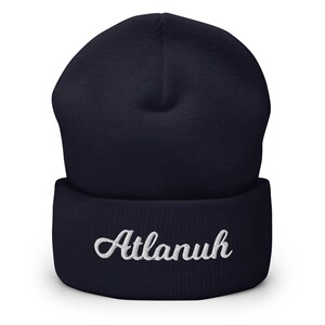 May include: A navy blue beanie with a white embroidered name "Atlanuh" on the cuff.