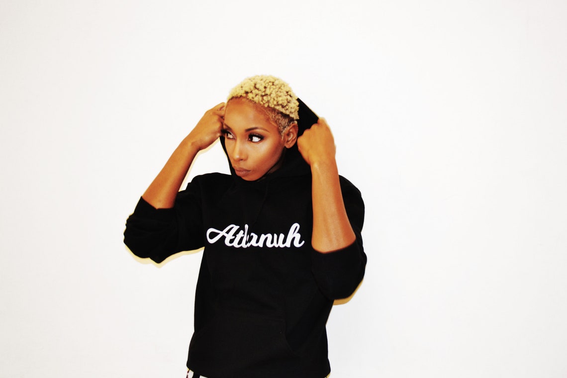 Model pulling up the hood on a black Atlanuh hoodie