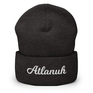 May include: A dark gray beanie with a white embroidered name "Atlanuh" on the cuff.