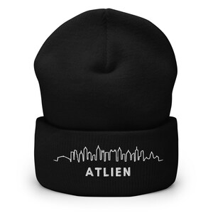May include: Black beanie with a white embroidered skyline and the word "ATLIEN" on the cuff.