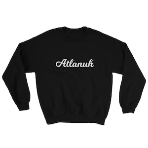May include: Black sweatshirt with the word "Atlanuh" written in white cursive lettering.
