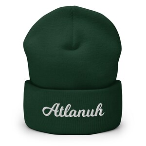 May include: A dark green beanie with a white embroidered name "Atlanuh" on the front.