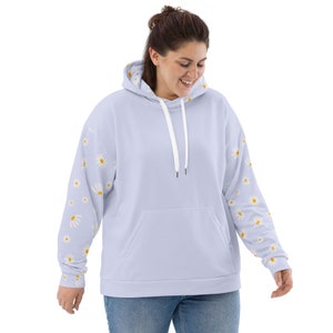 May include: A light blue hooded sweatshirt with a white drawstring and a kangaroo pocket. The sleeves feature a pattern of white daisies with yellow centers.