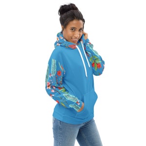 May include: A blue hoodie with a floral print on the sleeves. The hoodie has a white drawstring and a kangaroo pocket.