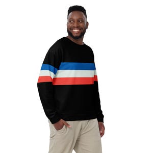 May include: A black sweatshirt with horizontal stripes in red, white, and blue. The sweatshirt has long sleeves and a crew neck.