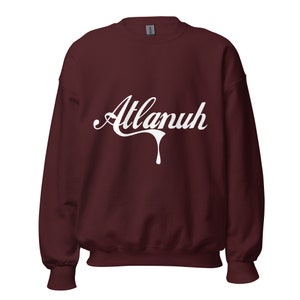 May include: A maroon sweatshirt with a white graphic of the word "Atlanuh" in a dripping font.