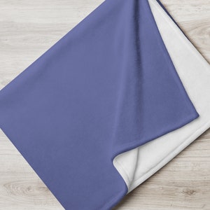 May include: A soft, plush throw blanket in a solid periwinkle blue color. The blanket is folded in half and the underside is white.