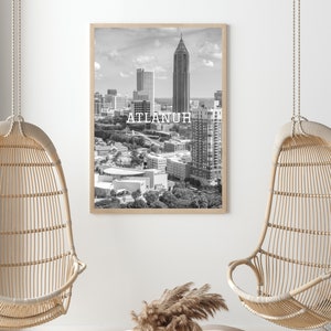 May include: Black and white photograph of the Atlanta skyline with the text "ATLANTA" printed in white on the image. The photograph is framed in a light wood frame.