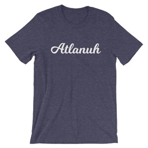 May include: A navy blue t-shirt with the word "Atlanuh" printed in white cursive lettering.