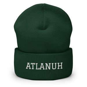 May include: A dark green beanie with a white embroidered word "ATLANUH" on the front.