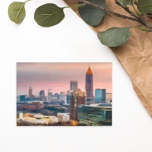 May include: A painting of a city skyline with a tall, red building in the center. The sky is a soft pink and purple, and the buildings are painted in a variety of shades of blue, gray, and brown.
