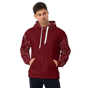 May include: A maroon hoodie with white abstract line designs on the sleeves. The hoodie has a white drawstring and a kangaroo pocket.