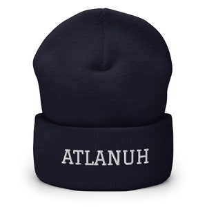 May include: A navy blue beanie with a white embroidered word "ATLANUH" on the front.