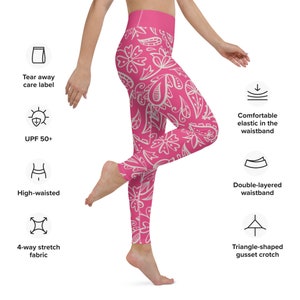 May include: Pink leggings with a white floral pattern. The leggings have a high waistband, a double-layered waistband, and a triangle-shaped gusset crotch. The leggings are made of 4-way stretch fabric and have a tear-away care label. The leggings also have a UPF 50+ rating.