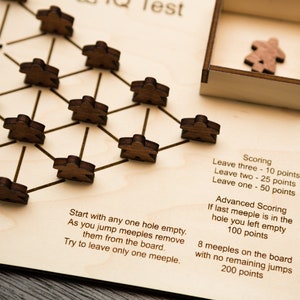 May include: Wooden IQ test game with a light wood board and dark wooden meeples. The game board has a network of lines and holes, with instructions and scoring details printed on the board. A small wooden box holds extra meeples.