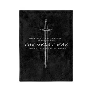 Op de afbeelding: Zwarte rechthoekige deken met een witte lijntekening van een zwaard. De tekst "YOUR HAND WAS THE ONE I REACHED FOR THE GREAT WAR I VOWED TO ALWAYS BE YOURS" is op de deken gedrukt.