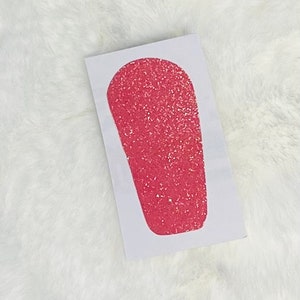May include: A pink glitter iron-on patch in the shape of a teardrop.