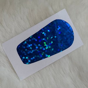 May include: A blue iridescent glitter vinyl decal in the shape of a tumbler. The decal is on a white background.