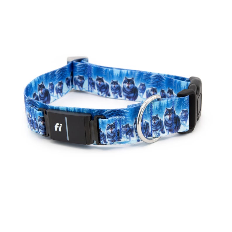 May include: A blue dog collar featuring a repeating pattern of wolves in a snowy forest. The collar includes a black plastic buckle, a metal D-ring, and a black rectangular electronic tracking module with the white text fi printed on the front.