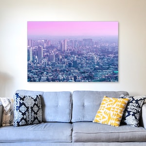 Puede incluir: Una vista panor&aacute;mica de un horizonte de ciudad con edificios altos y un cielo rosa y morado en el fondo.