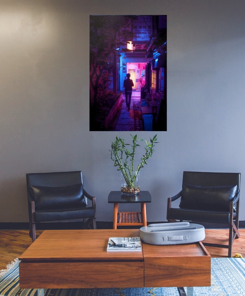 Puede incluir: Una persona camina por un callej&oacute;n estrecho y poco iluminado con luces de ne&oacute;n rosa y azul. El callej&oacute;n est&aacute; bordeado de edificios y plantas.