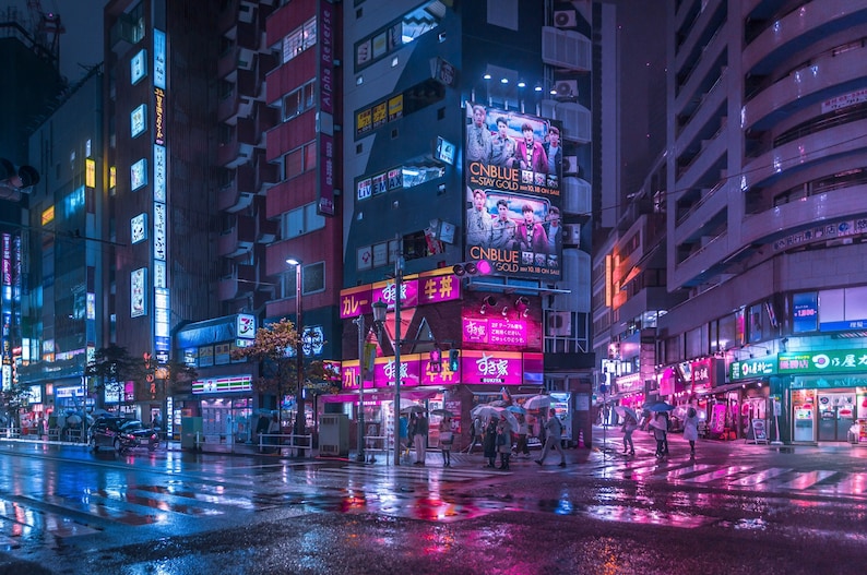 Pu&ograve; includere: Una scena di strada notturna a Tokyo, in Giappone, con insegne al neon e luci colorate che si riflettono sul marciapiede bagnato. La strada &egrave; fiancheggiata da edifici alti e ci sono persone che camminano sul marciapiede.