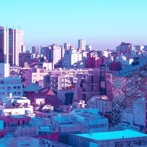 Puede incluir: Una vista a&eacute;rea de un horizonte urbano con una mezcla de edificios modernos y tradicionales. Los edificios son principalmente blancos y grises, con algunos acentos rosados y azules. El cielo es de un azul claro.