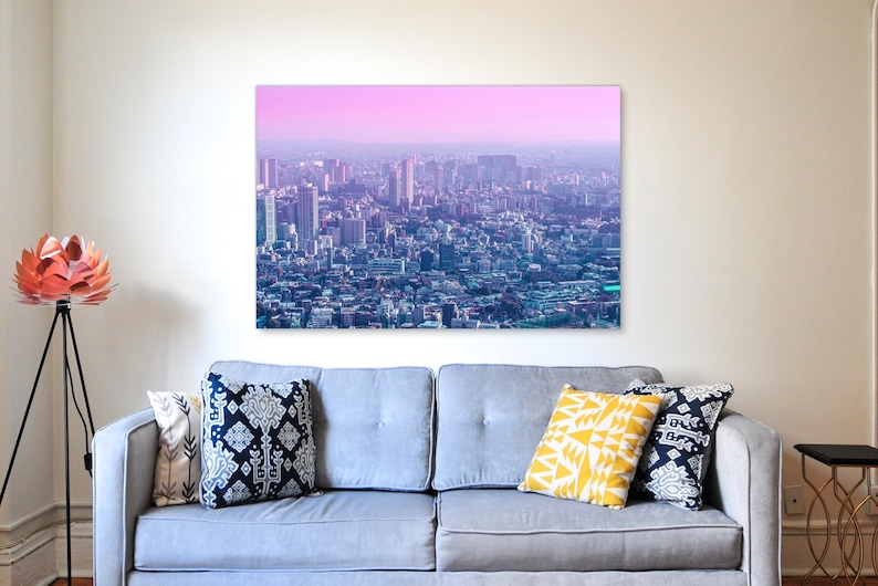 Puede incluir: Una vista panor&aacute;mica de un horizonte de ciudad con edificios altos y un cielo rosa y morado en el fondo.