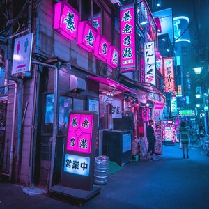 Puede incluir: Un callej&oacute;n estrecho y iluminado con ne&oacute;n en Jap&oacute;n con letreros en caracteres japoneses. Los letreros son de color rosa y morado y anuncian varios negocios. El callej&oacute;n est&aacute; bordeado de edificios y hay una persona caminando en la distancia.