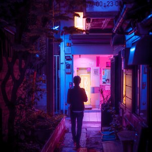 Puede incluir: Una persona camina por un callej&oacute;n estrecho y poco iluminado en Jap&oacute;n. Las paredes est&aacute;n llenas de letreros de ne&oacute;n, incluido uno que dice "Horario de atenci&oacute;n 1:30-14:30, 17:00-23:00".