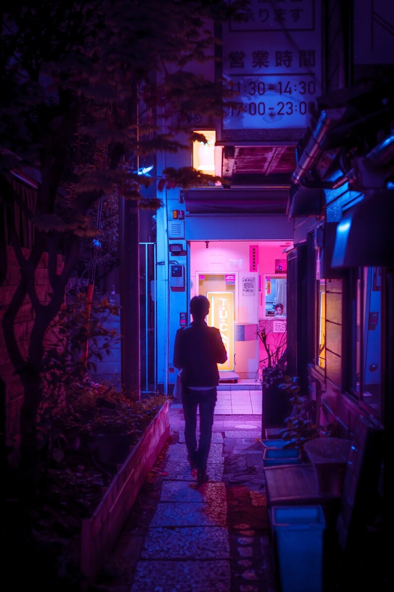Puede incluir: Una persona camina por un callej&oacute;n estrecho y poco iluminado en Jap&oacute;n. Las paredes est&aacute;n llenas de letreros de ne&oacute;n, incluido uno que dice "Horario de atenci&oacute;n 1:30-14:30, 17:00-23:00".