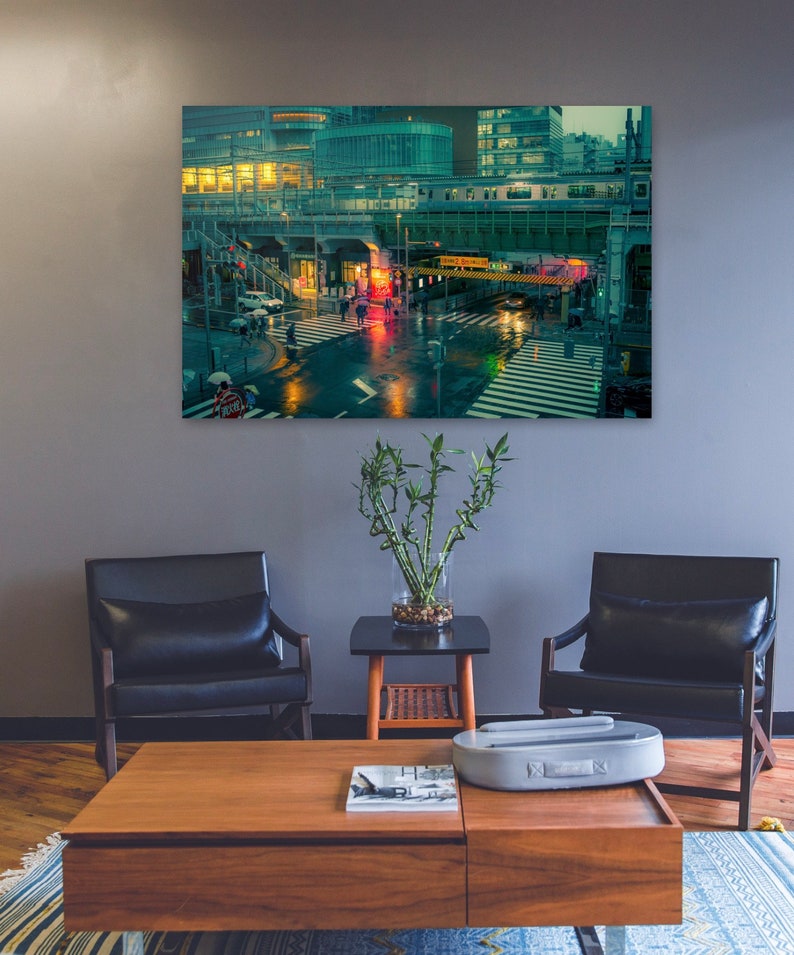 May include: A nighttime cityscape with a railway track overhead and a pedestrian crossing in the foreground. The city is lit up with neon lights and the street is wet from rain.