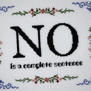 Può includere: Ricamo a punto croce bianco con bordi floreali blu e verdi. Il centro del ricamo presenta la parola "NO" in lettere nere, seguita dalla frase "is a complete sentence".