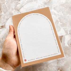 May include: A brown card with a white interior and rounded edges. The card has the text "things to do - brain dump - don't forget - things to do - brain dump - don't forget - things to do - brain dump - don't forget" repeated around the edge.