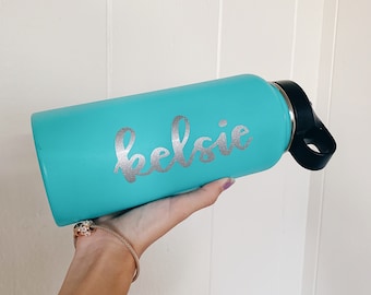May include: A turquoise water bottle with a silver vinyl decal that says "kelsie".