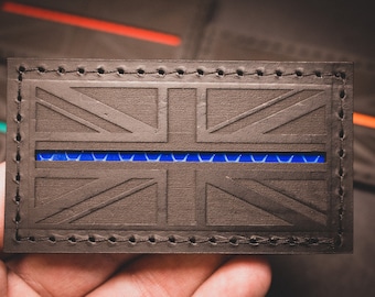 May include: A black leather wallet with a Union Jack design and a thin blue stripe across the middle.