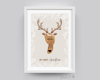 Può includere: Una stampa d'arte stampabile con una renna realizzata dall'impronta del piede di un bambino. La renna ha corna marroni e un viso sorridente. Il testo "MY FIRST Christmas" è stampato sotto la renna.