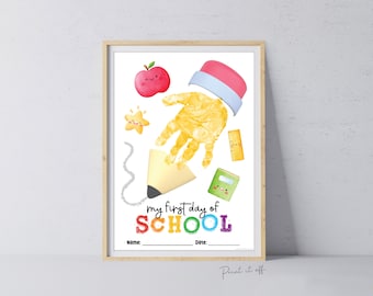 Puede incluir: Una manualidad imprimible de huella de mano para el primer día de escuela. La imagen muestra un lápiz amarillo con una huella de mano para la goma de borrar. Hay otras ilustraciones con temática escolar como una manzana, una estrella, una regla y un cuaderno. El texto dice "my first day of SCHOOL".