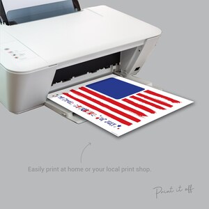 May include: A printable 4th of July design featuring a red, white, and blue American flag with the text "Happy 4th of July" and "We the People" printed on it. The design is being printed on a white printer.