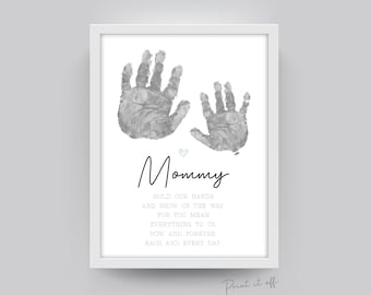 May include: A printable art print with a gray background featuring two handprints in gray and the text "Mommy" in black. The text below the handprints reads "Hold our hands and show us the way. For you mean everything to us, now and forever. Each and every day."