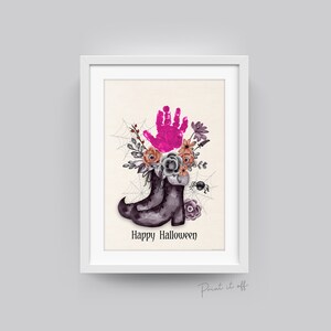 May include: A printable Halloween-themed art print featuring a pair of black witch boots with a pink handprint and floral arrangement on top. The text "Happy Halloween" is printed below the boots.