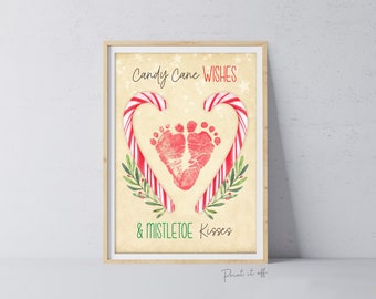 May include: A printable Christmas card featuring a red heart made of candy canes with a baby's footprint inside. The text reads "Candy Cane Wishes & Mistletoe Kisses".